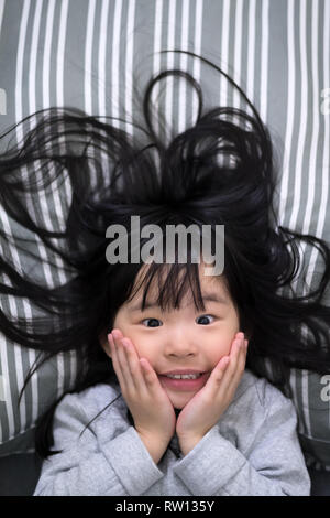 Young girl wakes up in the morning smiling Stock Photo