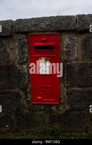 Remote red Royal Mail post box with the letters GR (for George Rex - King George) on the Isle of Erraid, Isle of Mull, Scotland Stock Photo