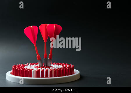 Dartboard with three dart arrows hitting the center Stock Photo
