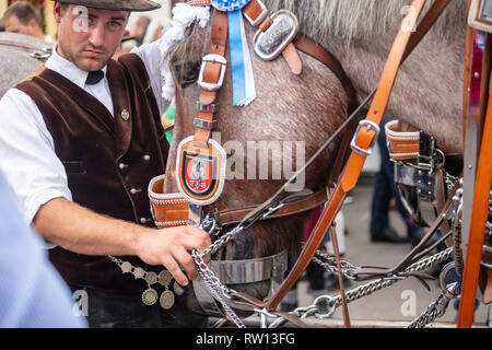 October 7, 2018. Munich, Germany, Oktoberfest, Man in traditional costume holding a decorated horse Stock Photo