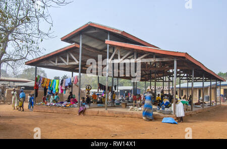 A photo of a local fresh market building in Kongo village, rural Ghana. Vendors selling and wearing local fabrics can be seen. Stock Photo