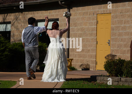 Bride and groom walking together celebrating after wedding ceremony Stock Photo