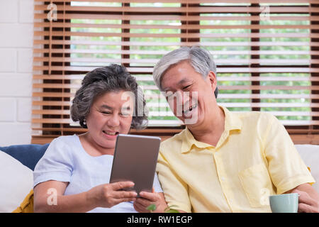 Asian senior couple learn to using table compute on sofa in living room at home.senior with technology lfiestyle.aging at home concept Stock Photo
