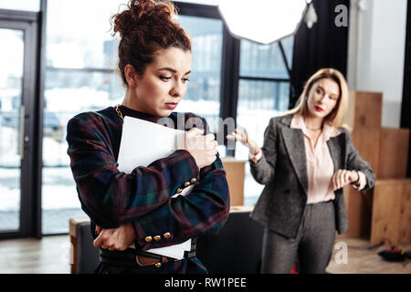 Curly dark-haired trainee feeling emotional after not getting job Stock Photo