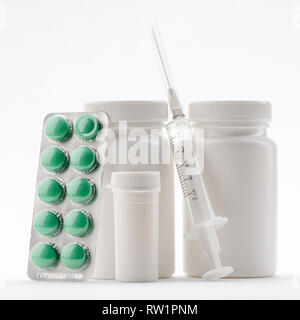 Different pills and filled syringe Stock Photo