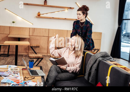 Designer having inspiration while having massage by secretary Stock Photo