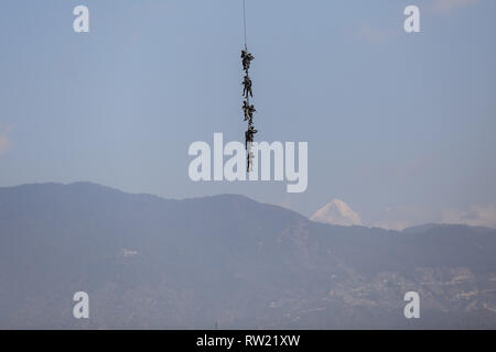 Nepalese Army soldiers demonstrate rescue skills aboard of an helicopter (not pictured) during the Nepal Army Day celebration.  Nepal Army Day is celebrated annually during Hindu festival Shivaratri. Stock Photo