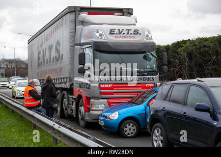 HGV traffic accident with car on dual carriageway; TRC on the A565 Gravel lane roundabout between DAF heavy goods vehicle and small Ford compact family car which ended up being pushed sideways down the road. Stock Photo