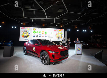 Geneva, Switzerland. 4th Mar, 2019. Ian Callum (1st R), Design Director for Jaguar, delivers a speech beside a Jaguar I-PACE at the Palexpo in Geneva, Switzerland, on March 4, 2019. Jaguar's first electric SUV I-PACE won the Car of the Year award on Monday in a neck-to-neck race against Alpine A110 on the eve of the 89th Geneva International Motor Show (GIMS). Credit: Xu Jinquan/Xinhua/Alamy Live News Stock Photo