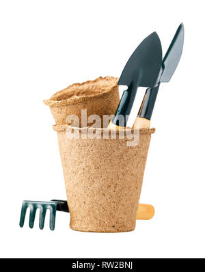 Shovels and rakes in peat pot for working in the garden isolated on white background Stock Photo