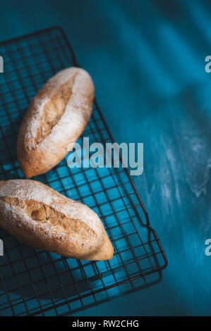 Baguette, European style bread on blue wood table in morning time with hard light effect. Organic and healthy meal in minimal style concept