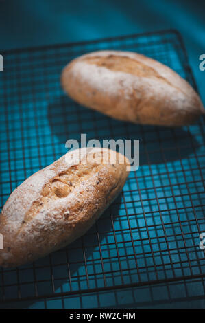 Baguette, European style bread on blue wood table in morning time with hard light effect. Organic and healthy meal in minimal style concept