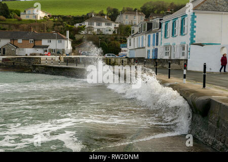 Editorial: People & Logos. Portmellon, Mevagissey, Cornwall, UK. 03/03/2019. Large swells kicked up by storm Freya crash against the sea defences. Stock Photo