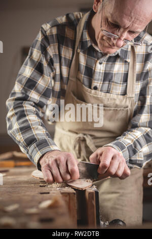Experienced craftsman working manually on a piece of wood Stock Photo