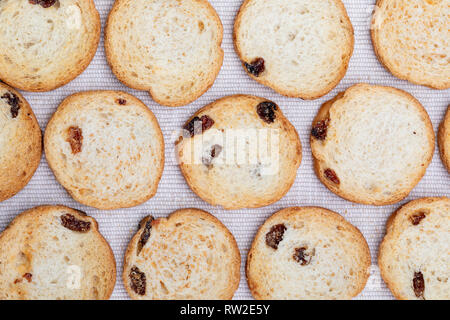 Mini round toasts of bread with raisins. Background. On delicate fabric background. Stock Photo