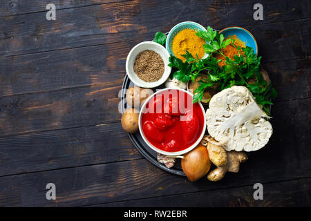 Ingredients for cooking curry cauliflower on dark background top view Stock Photo