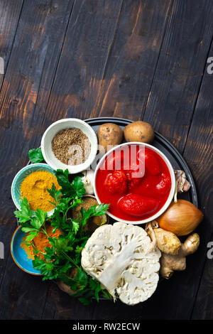 Curry cauliflower raw ingredients for cooking on dark background with copy space top view Stock Photo