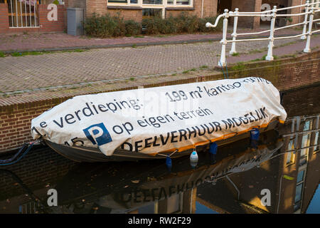 Leiden, Holland - February 25, 2019: Funny Dutch text on the boat tarp, for rent 199 square meters on the first floor Stock Photo