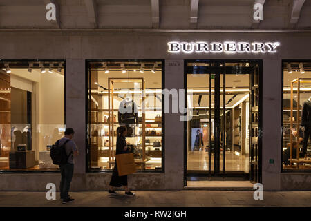 retail outlet in Calle Larga XXII Marzo, Marco, Venice, Veneto, Italy illuminated at night with signage with people passing. Luxury goods Stock Photo - Alamy