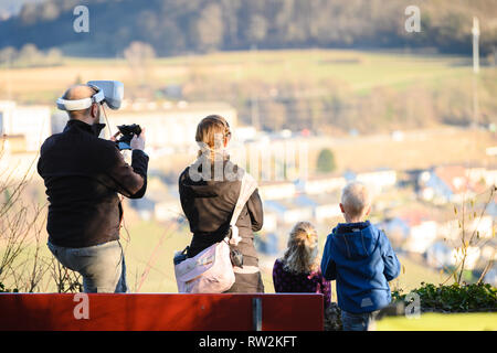 Man with his family controls the drone in the sky Stock Photo