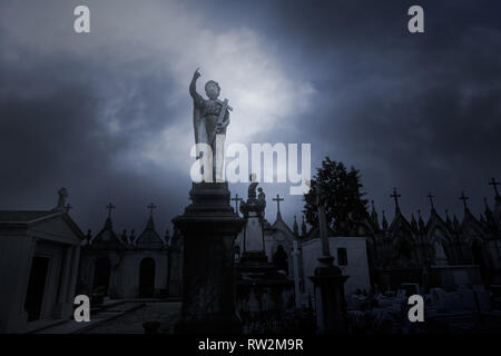 Overcast sad cemeteryb with an angel statue on the foreground Stock Photo