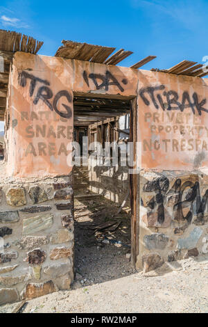 Remains of building at the ghost town of Garlock, California. A building missing the roof, with concrete block walls that the lower half is rock facin Stock Photo