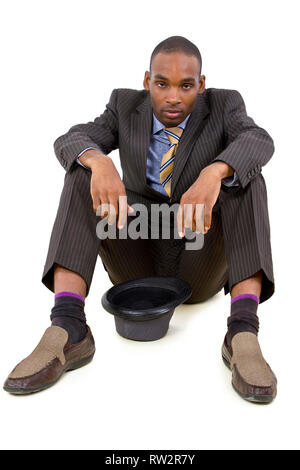 young depressed black businessman sitting in a corner Stock Photo