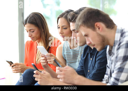 Addicted group of friends using their smart phones at the same time at home Stock Photo