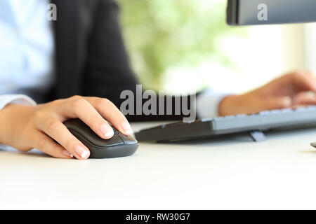 Close up of an office worker hand using computer mouse on a desktop Stock Photo
