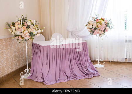 Banquet room with dining tables for guests during the wedding ceremony. Stock Photo