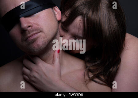 Female zombie vampire bites man in the neck Stock Photo