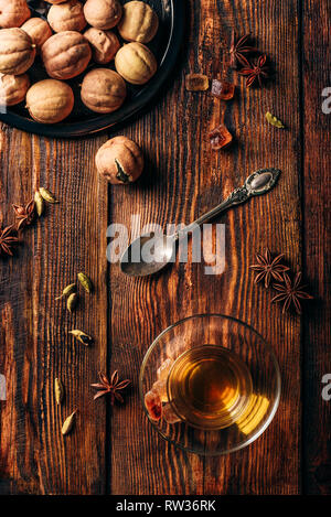 Arabic tea with different spices in armudu glass over wooden surface. View from above Stock Photo