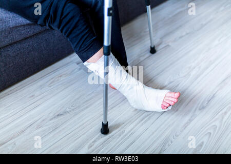 The man is trying to walk with a broken leg Stock Photo