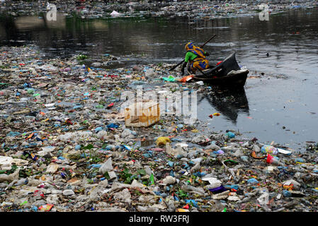 A Bangladesh woman collects plastic from the polluted Turag River in Dhaka, Bangladesh, on February 28, 2019. Bangladesh has been reportedly ranked 10 Stock Photo