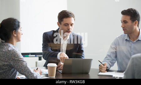 Serious businessman making online business project presentation at group negotiations Stock Photo