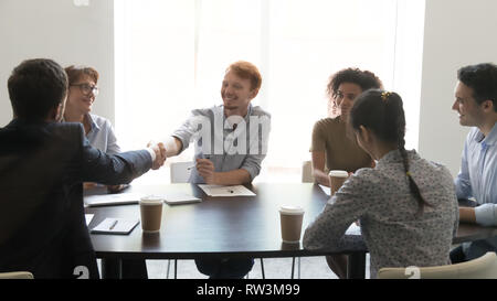 Happy businessmen shake hands at diverse group meeting negotiations Stock Photo