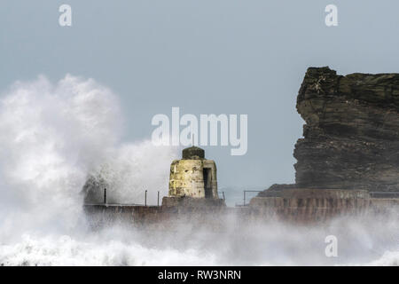 Storm Freya battering the Cornish coast with huge powerful waves breaking over the historic Monkey Hut on the pier at Portreath in Cornwall Stock Photo