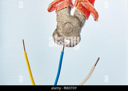 Electrician uses end cutting pliers for cutting wires during the installation of electrical wiring. Stock Photo