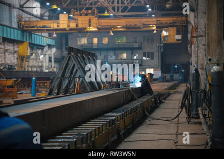 A man worker using a welding machine on a construction site indoors Stock Photo