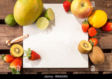 https://l450v.alamy.com/450v/rw46w4/concrete-stone-server-with-space-for-text-on-a-rustic-wood-plank-surface-and-arranged-fruits-apple-lemon-strawberries-kiwis-limes-and-mango-rw46w4.jpg