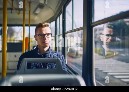 Young man listening music in tram. Travel by public transportation. Stock Photo