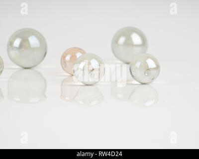 Glass marbles on a grey surface. beautiful reflection, abstract background Stock Photo