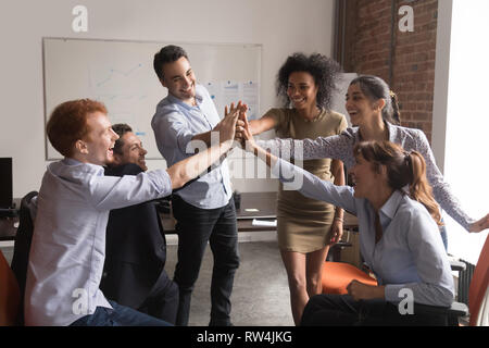 Happy diverse office employees group give high-five, corporate trust concept Stock Photo