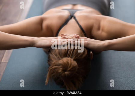 Woman practicing yoga, doing neck strengthening exercises on mat Stock Photo