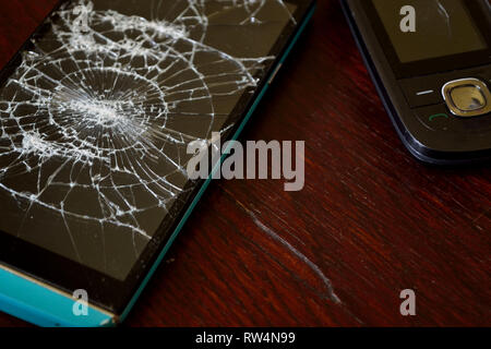 Mobile phone with broken screen. Cracked smartphone screen Stock Photo
