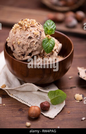 Fresh hazelnut ice cream on wooden plate close up Stock Photo