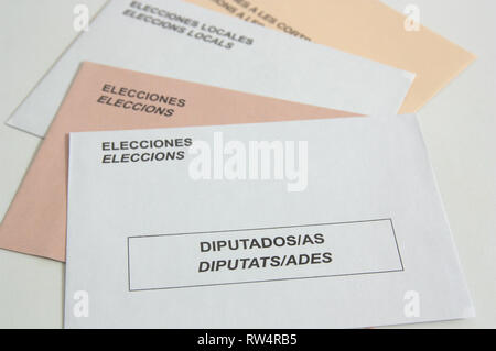 View of Spanish electoral envelopes of white and sepia colors in a fan on a table. The words that are seen are in Spanish (Elecciones, elecciones loca Stock Photo