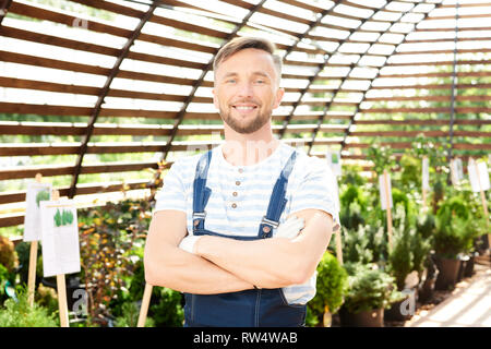 Smiling Worker Posing in Garden Stock Photo