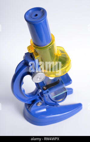Blue plastic children's microscope on white background. Stock Photo