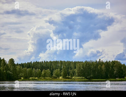 Majestic thunder clouds forming in the bright summer day sky in Finland. Stock Photo
